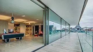 Moderne stue med store skyvedører i glass og utsikt til en byterrasse